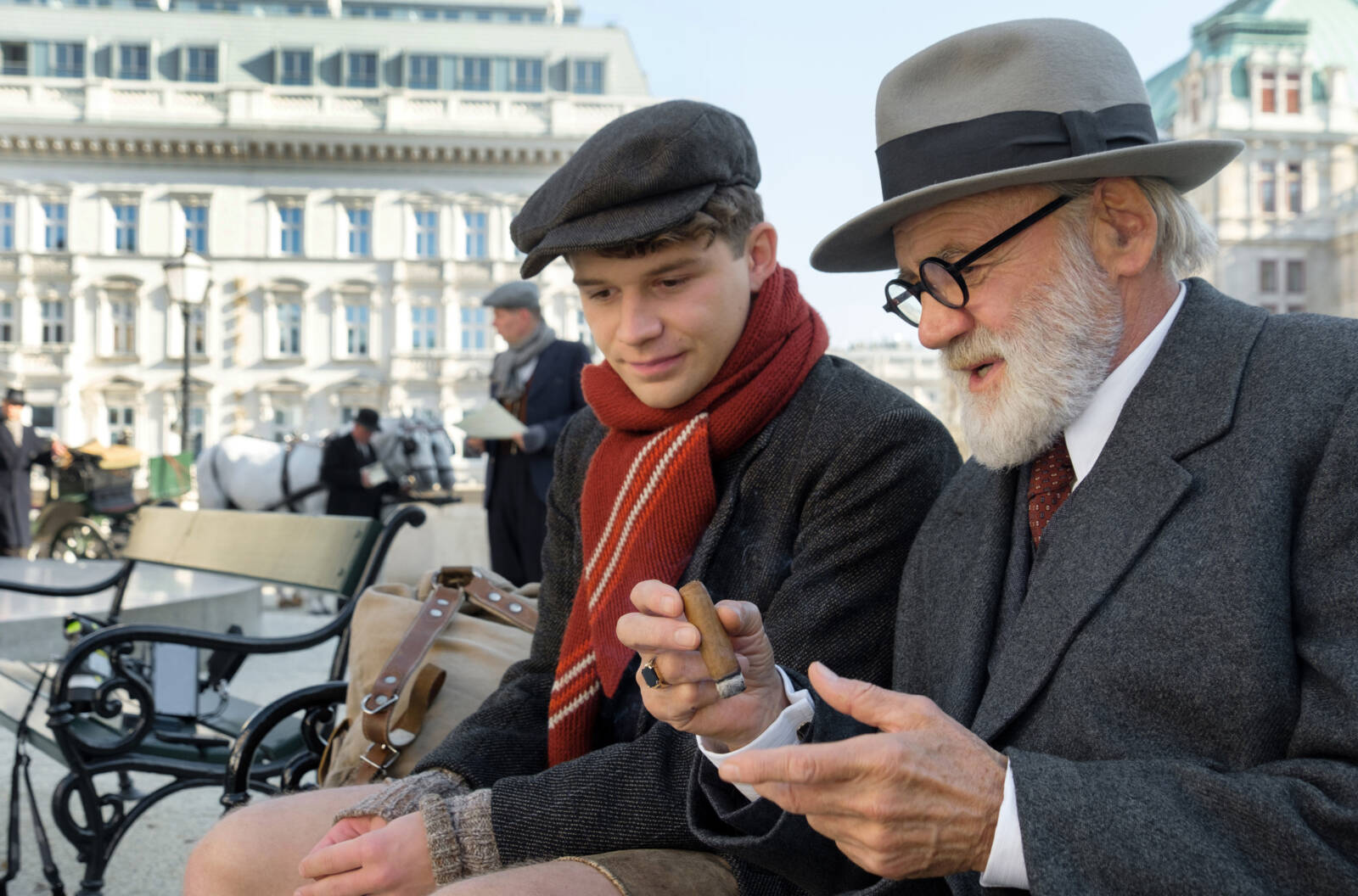 Franz Huchel (Simon Morzé, li.) und Siegmund Freud (Bruno Ganz) auf einer Parkbank mit Zigarre in der Hand.