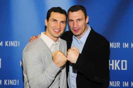 Wladimir (links) und Vitali Klitschko Arm in Arm vor einer blauen Pressewand.