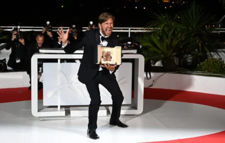 „Triangle of Sadness“-Cannes: Ruben Östlund freut sich auf der Bühne, mit dem Preis Goldene Palme in der Hand.