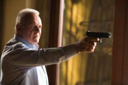 Anthony Hopkins als Ted Crawford hält in seiner ausgestreckten Hand eine Pistole.