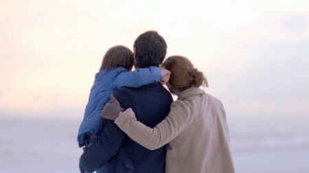 „Das Leben gehört uns“: Im Vordergrund ist eine Familie, der Mann in der Mitte hat ein Kind auf dem Arm, die Frau rechts von ihm hat den Arm um den Mann gelegt, gemeinsam schauen sie auf den, in weiches Licht getauchten Horizont