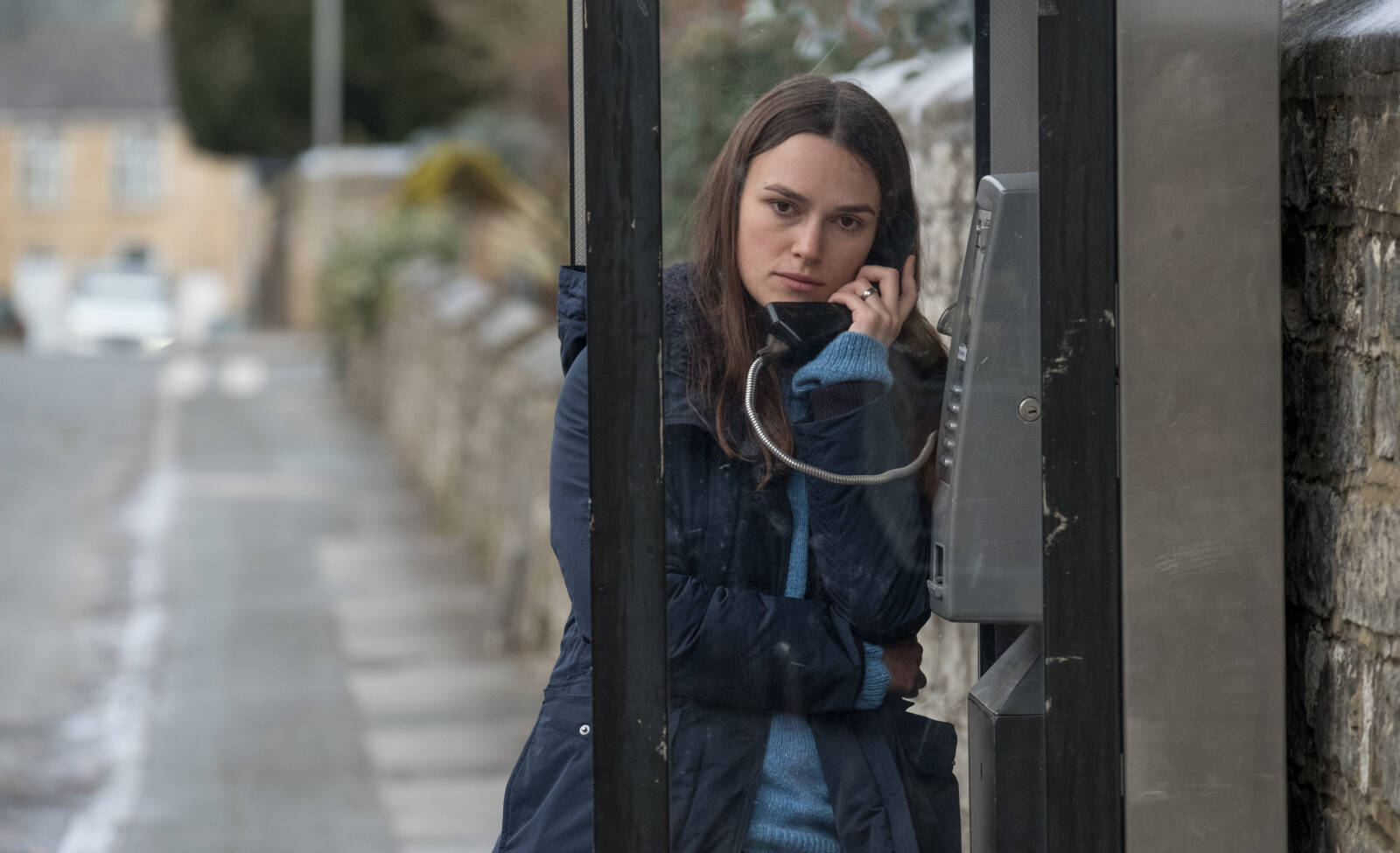 „Official Secrets – Gefährliche Geheimnisse“: Man sieht Keira Knightly in einer Telefonzelle einer leeren Straße mit einem dunkelblauen Mantel.