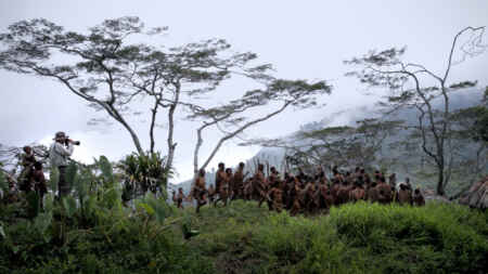 Sebastião Salgado mit Kamera (l.) fotografiert ein tänzerisches Ritual eines lateinamerikanischen(?), indigenen Volkes.