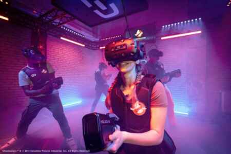 „Ghostbusters VR“: Man sieht 4 junge Menschen in einem nebeligen Raum. Sie tragen VR-Brillen und schwarze Waffen und sind auf der Jagd nach Geistern.