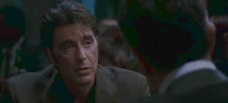 „Heat 2“: Al Pacino als Lt. Hanna in „Heat“, er sitzt Robert De Niro gegenüber, dessen Hinterkopf und Schultern in der rechten Bildhälfte zu sehen sind, Pacino ist mittig/links im Bild von vorne zu sehen, er hat keinen Bart und trägt einen Anzug.