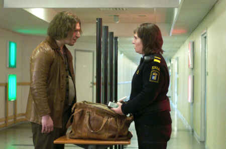Tina (Eva Melander) und Vore (Eero Milonoff) stehen sich gegenüber und schauen sich an. Tina trägt eine Zoll-Uniform und untersucht Vores Tasche, Vore trägt eine alte Lederjacke.