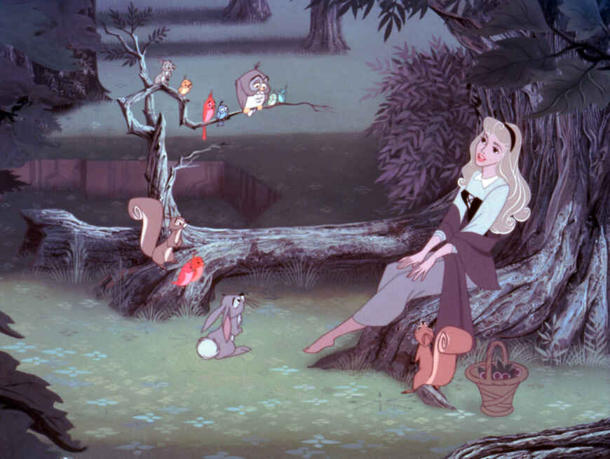 „Dornröschen“ im TV: Man sieht Prinzessin Aurora im Wald, sie sitzt auf einer Wurzel und spricht zu den Tieren des Waldes.