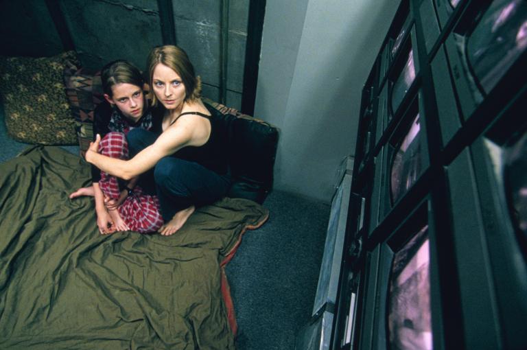 „Panic Room“ im TV: Man sieht Jodie Foster und Kristen Stewart auf dem Boden des Panikraums, rechts sind Monitore.