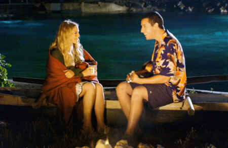 „50 erste Dates“ im TV: Man sieht Dres Barrymore (l.) und Adam Sandler, sie sitzen auf einem Kanu am Lagerfeuer und unterhalten sich angeregt.