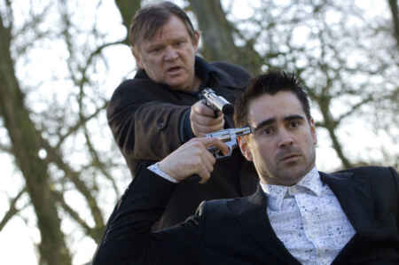 „Brügge sehen … und sterben?“ im TV: Man sieht Brendan Gleeson als Ken hinten stehen, wie er Colin Farrell als Ray eine Pistole an den Kopf hält, auch Farrell hält sich eine Pistole an den Kopf.