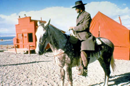 „Ein Fremder ohne Namen“ im TV: Man sieht Clint Eastwood (jung) auf einem Pferd sitzend, er trägt einen Hut und einen Mantel, im Hintergrund ein Cowboy-Dorf.